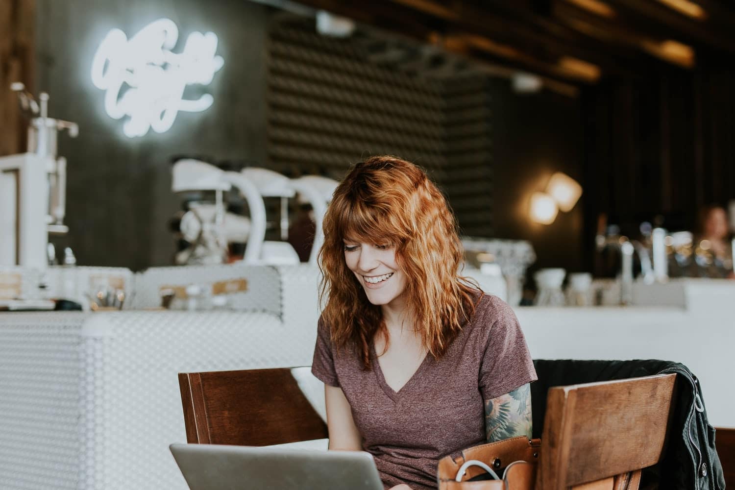 Woman working on laptop in a trendy cafe