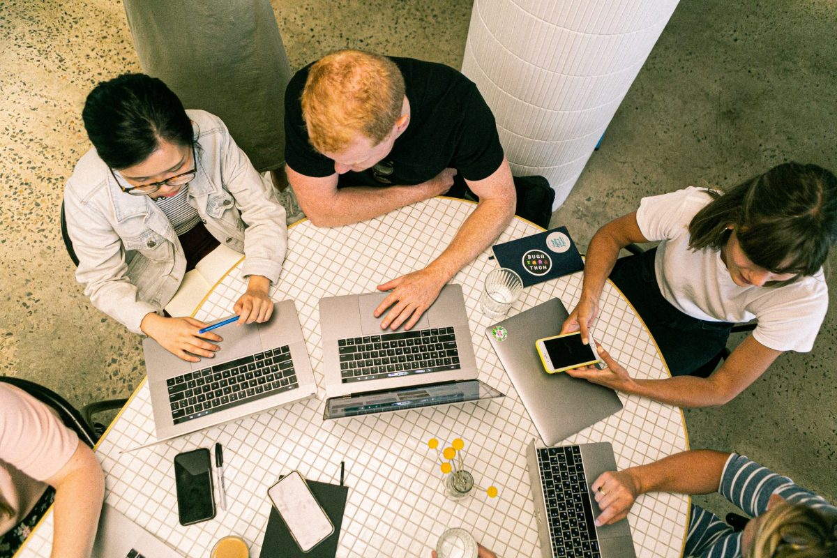 A team of marketing experts discussing with one another while seated at a table.