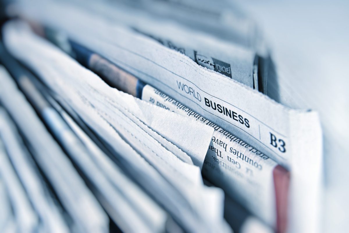 A group of newspapers with one showing the title “World Business”