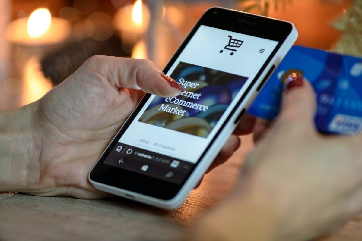 A person holding a phone with the screen showing an e-commerce platform