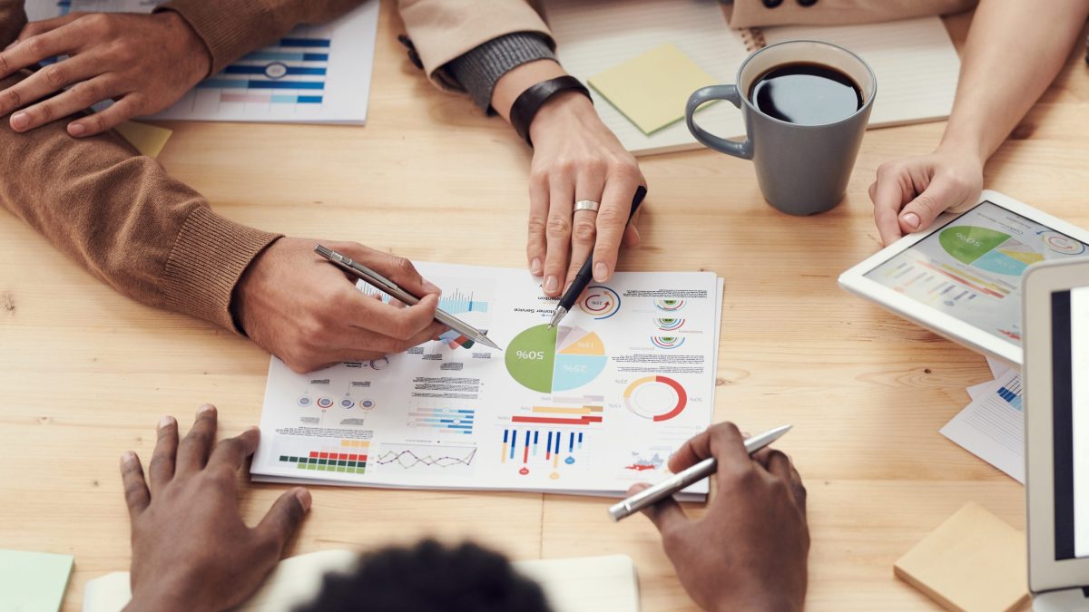 A group of marketing experts seated around a table analyzing data