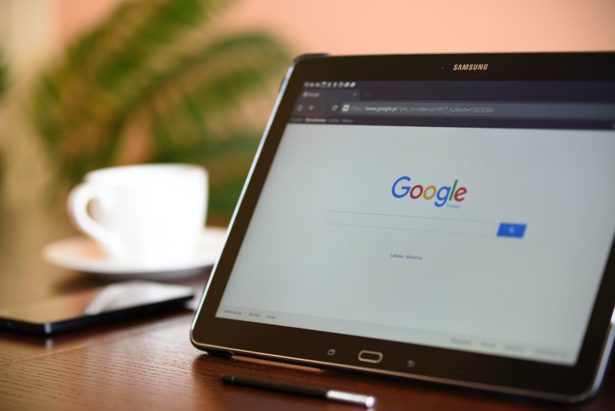 A tablet set on a table with the screen showing the Google search home page