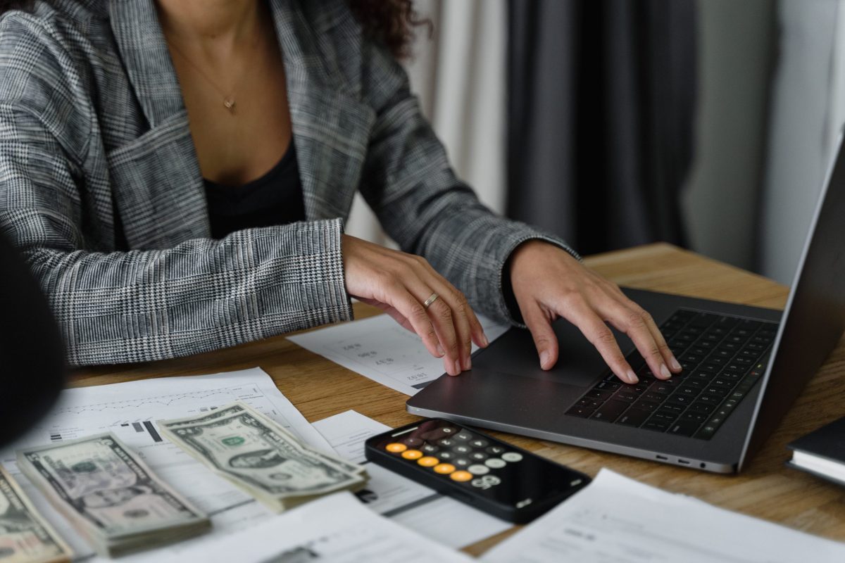 A business professional calculating finances while reviewing papers