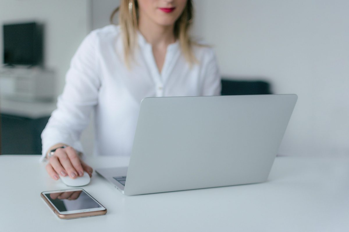 A woman seated at a table using a laptop