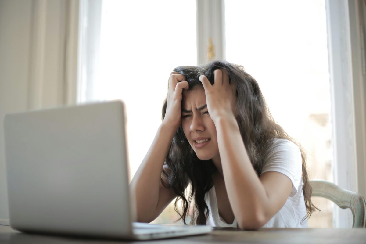 jakob-owens-WUmb_eBrpjs-unsplash Frustrated woman clutching her head while staring at a laptop screen